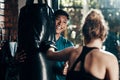 Now youre punching. a handsome young male fitness instructor coaching a female boxer in a gym.