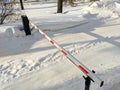 Noyabrsk, Russia - February 20, 2022: View of an automatic barrier with a post standing in a snowdrift in winter restricting Royalty Free Stock Photo