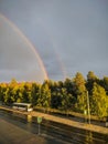 Noyabrsk, Russia - May 30, 2020: City street after rain on the background of sunset and rainbow. Vertical