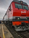 Noyabrsk, Russia - May 15, 2020: People and a train stand on the platform of the station. Vertical