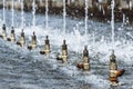 Nozzles in a public fountain shoot water into the sky.