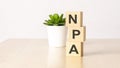 NPA - Non Performing Assets - acronym on wooden cubes on wooden backround. business concept