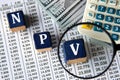 NPV - acronym on wooden cubes against the background of banknotes and calculator Royalty Free Stock Photo