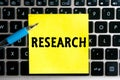 nscription `Research` on a yellow sheet of sticker paper on the background of a computer keyboard