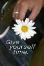 Nspirational words - give yourself time. Self grow and improvement motivational quote concept with person holding white flower.