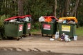 Overfilled garbage wheelie bins with colourful lids for general and recycling wast