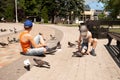 Two children feed pigeons sitting on the ground