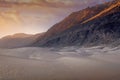 Misty orange and golden sunrise over the white sand dunes of the Nubra valley, India