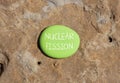 Nuclear fission symbol. Concept words Nuclear fission on beautiful big green stone. Beautiful stone wall background. Business