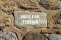 Nuclear fission symbol. Concept words Nuclear fission on beautiful big stone. Beautiful stone wall background. Business science