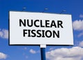 Nuclear fission symbol. Concept words Nuclear fission on beautiful big white billboard. Beautiful blue sky cloud background.