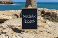 Nuclear fission symbol. Concept words Nuclear fission on beautiful black chalk blackboard. Chalkboard. Beautiful stone sea sky