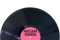 Nuclear fission symbol. Concept words Nuclear fission on beautiful black vinyl disk. Beautiful white table white background.