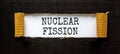 Nuclear fission symbol. Concept words Nuclear fission on beautiful white paper. Beautiful black paper background. Business science