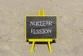 Nuclear fission symbol. Concept words Nuclear fission on beautiful black chalk blackboard. Chalkboard. Beautiful sand background.