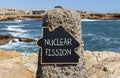 Nuclear fission symbol. Concept words Nuclear fission on beautiful black chalk blackboard. Chalkboard. Beautiful stone sea sky