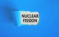 Nuclear fission symbol. Concept words Nuclear fission on beautiful white paper. Beautiful blue paper background. Business science