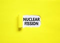 Nuclear fission symbol. Concept words Nuclear fission on beautiful white paper. Beautiful yellow paper background. Business