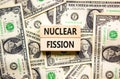 Nuclear fission symbol. Concept words Nuclear fission on beautiful wooden blocks. Dollar bills. Beautiful background from dollar