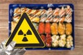 a nuclear radiation warning sign above blurred sushi horizontal composition Royalty Free Stock Photo