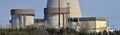 Nuclear reactor containment buildings with cooling tower in background