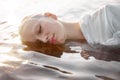 Nude naked sexy woman in water at sunset. Beautiful blonde woman with short wet hair and big breasts, art portrait in sea Royalty Free Stock Photo