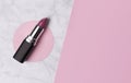 Nude pink lipstick on creative marble and pastel pink background with copy space