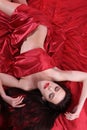 Nude woman on red satin covered herself bed sheets Royalty Free Stock Photo