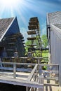 Closeup of old wooden water paddle wheel in ancient dutch watermill, sun rays backlight