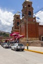 Nuestra SeÃ±ora de las Mercedes church and several people and cars leaving the church at noon, located in Carhuaz, Peru