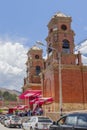 Nuestra SeÃ±ora de las Mercedes church and several people and cars leaving the church at noon, located in Carhuaz, Peru