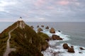 Nugget point and lighthouse above the cliffs in the Pacific Ocean. New Zealand, South Island Royalty Free Stock Photo