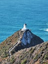 Nugget Point lighthouse with blue Pacific ocean waters on the background Royalty Free Stock Photo