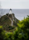 Nugget Point Lighthouse on a mountain in front of the water in New Zealand Royalty Free Stock Photo