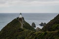 Nugget Point Lighthouse on a mountain in front of the water in New Zealand Royalty Free Stock Photo