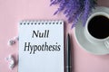 NULL HYPOTHESIS - words in notebook on pink background with cup of coffee and lavender flowers Royalty Free Stock Photo