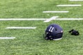 Number 11 American Football helmet and a pair of white gloves laying on the grass Royalty Free Stock Photo
