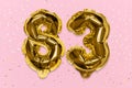 The number of the balloon made of golden foil, the number eighty-three on a pink background with sequins.