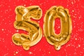 The number of the balloon made of golden foil, the number fifty on a red background with sequins. Birthday greeting card