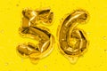 The number of the balloon made of golden foil, the number fifty-six on a yellow background with sequins.