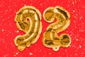 The number of the balloon made of golden foil, the number ninety-two on a red background with sequins.