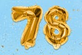 The number of the balloon made of golden foil, the number seventy-eight on a blue background with sequins