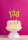 Number 138 birthday candle - Pink celebration cake with drip icing Royalty Free Stock Photo