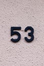 Number 53 black house number on white wall