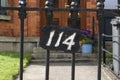 Black and white house number plate on the fence. Number 114. Ireland Dublin, Royalty Free Stock Photo
