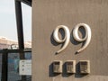 Number 99 building sign hanging outside of gated entry way