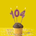 Number 104 candle - Birthday candle with chocolate cupcake Royalty Free Stock Photo