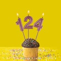Number 124 candle - Birthday candle with chocolate cupcake Royalty Free Stock Photo