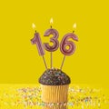 Number 136 candle - Birthday candle with chocolate cupcake Royalty Free Stock Photo