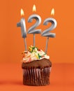 Number 122 candle - Birthday cupcake on orange background